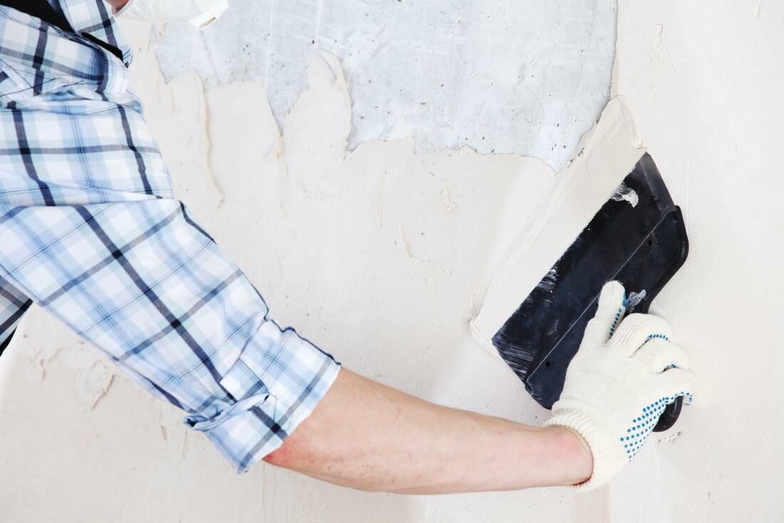A man plastering in wall 